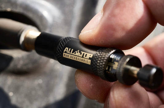 Primer plano del Kit de Desinflado Automático ALL-TOP para herramientas Off-Road ajustando válvula de neumático