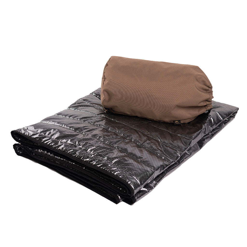 Manta Térmica con Tecnología Thermaheat plegada junto a su funda marrón de la marca Goubet