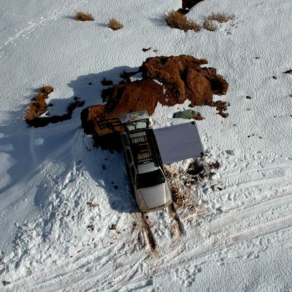 Toldo Lateral de AndesRacks instalado en camioneta sobre nieve para protección en exteriores