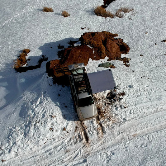 Toldo Lateral de AndesRacks instalado en camioneta sobre nieve para protección en exteriores