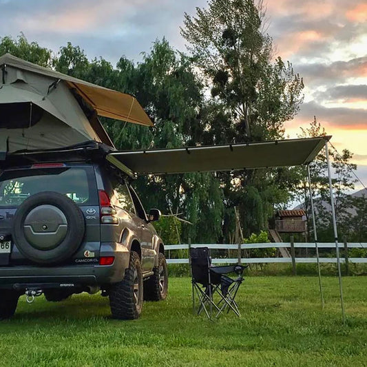 Toldo Lateral TRIBU montado en un vehículo con paisaje natural al atardecer